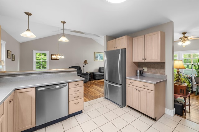 2410 Bruynswick Rd, Wallkill, NY 12589 - kitchen featuring appliances with stainless steel finishes, light brown cabinetry, healthy amount of natural light, light tile patterned floors, and lofted ceiling