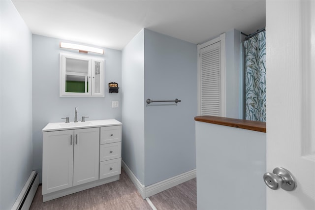 2410 Bruynswick Rd, Wallkill, NY 12589 - bathroom with baseboard heating, wood finished floors, vanity, and baseboards