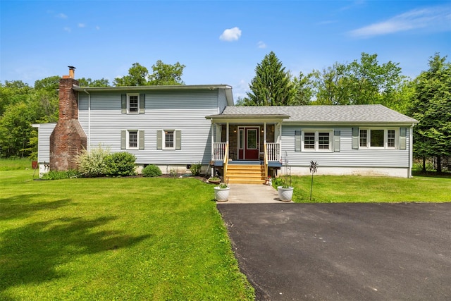 2410 Bruynswick Rd, Wallkill, NY 12589 - view of front facade with a chimney, a front yard, and covered porch