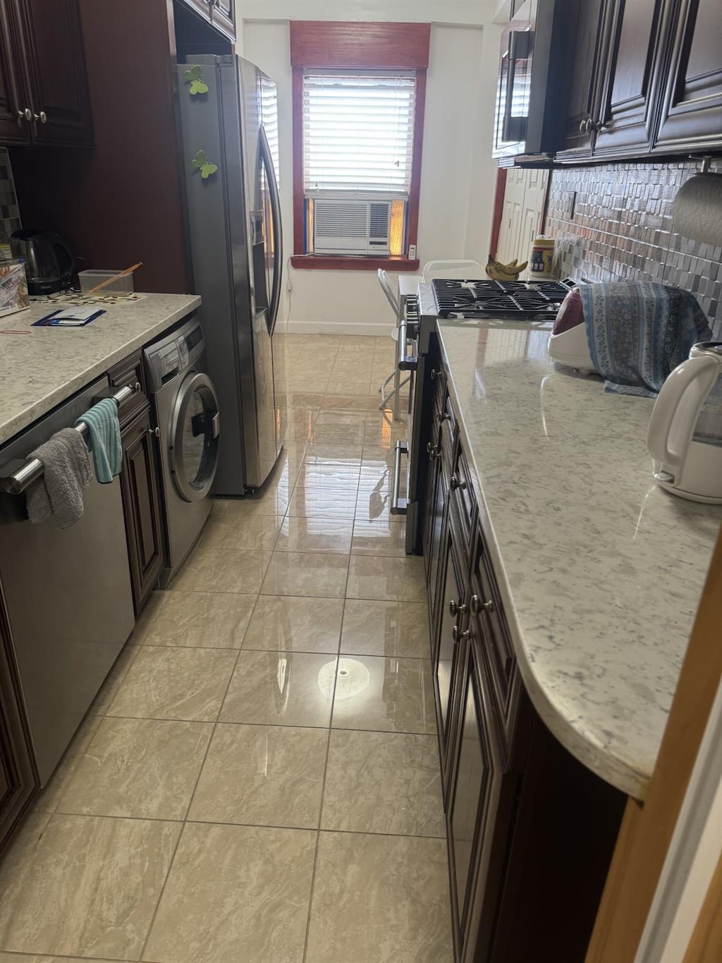 3591 161st St Unit 2J, Flushing, NY 11358 - kitchen with washer / clothes dryer, stainless steel appliances, light stone counters, cooling unit, and baseboards