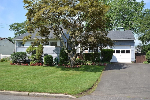 1318 Brooklyn Blvd, Bay Shore, NY 11706 - view of property hidden behind natural elements featuring asphalt driveway, a garage, roof with shingles, and a chimney