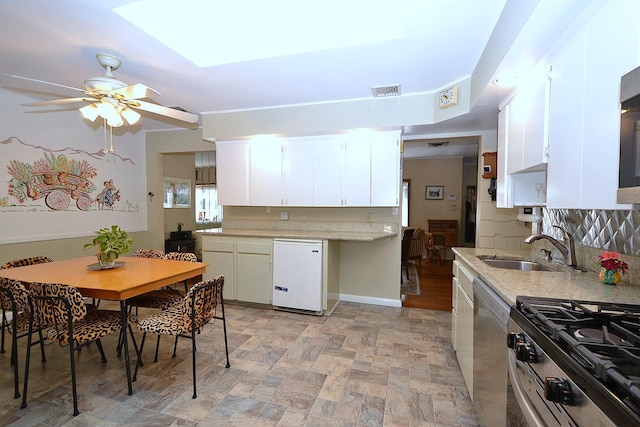 1318 Brooklyn Blvd, Bay Shore, NY 11706 - kitchen with stainless steel appliances, ceiling fan, stone finish floors, tasteful backsplash, and white cabinets