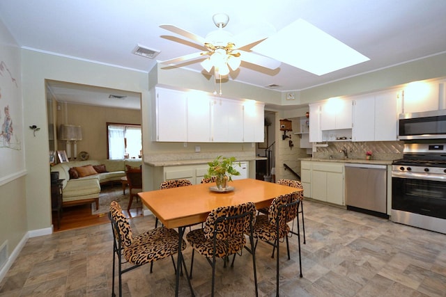 1318 Brooklyn Blvd, Bay Shore, NY 11706 - dining area with a ceiling fan, a skylight, stone finish floors, and crown molding
