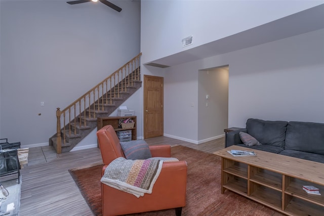 15 Candlestick Ct, Warwick, NY 10990 - living room featuring stairway, a high ceiling, a ceiling fan, baseboards, and wood finished floors