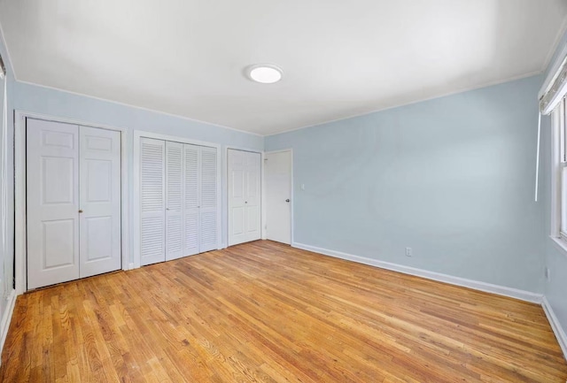 5814 229th St, Bayside, NY 11364 - unfurnished bedroom with two closets, light wood-style floors, and baseboards