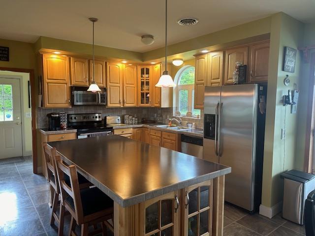 6452 State Route 52, Lake Huntington, NY 12752 - kitchen featuring appliances with stainless steel finishes, healthy amount of natural light, a kitchen island, and tasteful backsplash