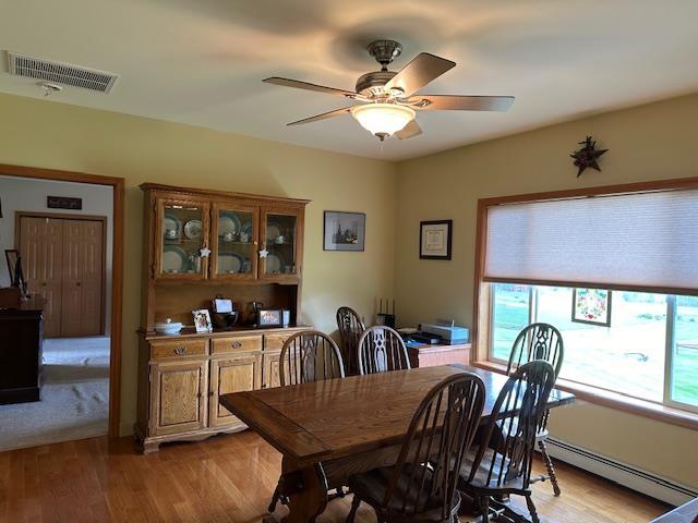 6452 State Route 52, Lake Huntington, NY 12752 - dining space featuring a baseboard radiator, light wood-style floors, and ceiling fan