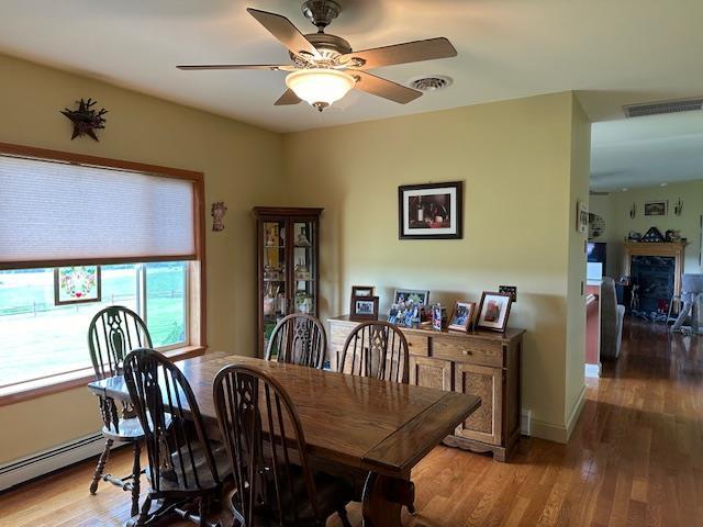 6452 State Route 52, Lake Huntington, NY 12752 - dining room featuring baseboard heating, light wood finished floors, and a ceiling fan