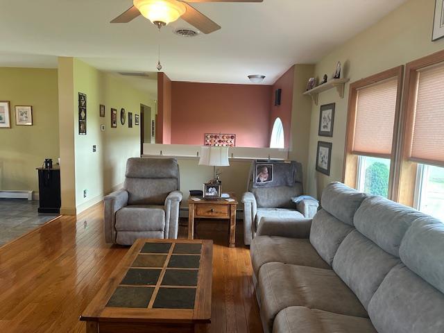 6452 State Route 52, Lake Huntington, NY 12752 - living area with a ceiling fan, hardwood / wood-style flooring, and a baseboard heating unit