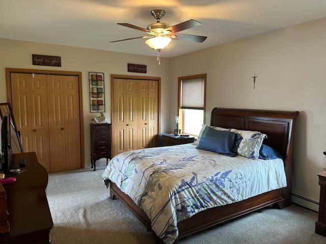 6452 State Route 52, Lake Huntington, NY 12752 - carpeted bedroom featuring a baseboard radiator, two closets, and ceiling fan