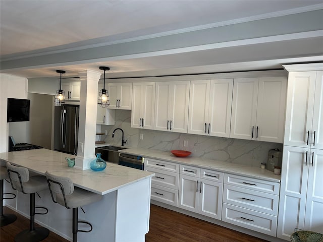 855 E Broadway Unit 3D, Long Beach, NY 11561 - kitchen with stainless steel appliances, white cabinets, tasteful backsplash, a sink, and decorative light fixtures