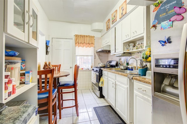 9 Adler Pl, Brooklyn, NY 11208 - kitchen with appliances with stainless steel finishes, light tile patterned floors, white cabinetry, under cabinet range hood, and light countertops