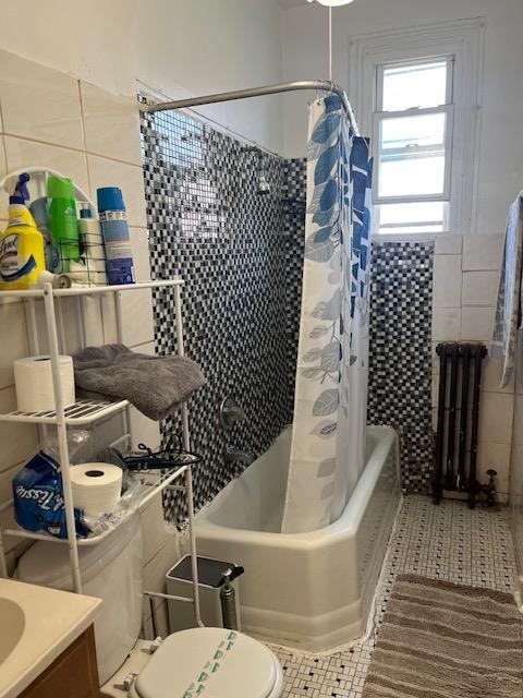 5436 Nurge Ave, Maspeth, NY 11378 - full bath featuring radiator, tile walls, toilet, shower / tub combo, and tile patterned floors