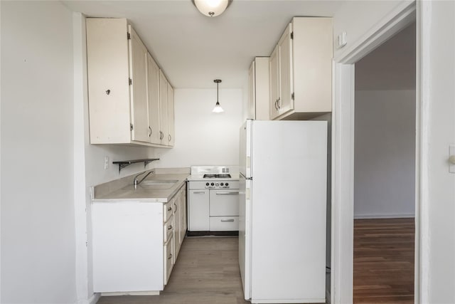 67-09 136th St Unit B, Kew Garden Hills, NY 11367 - kitchen with white appliances, light wood-style floors, light countertops, pendant lighting, and white cabinets