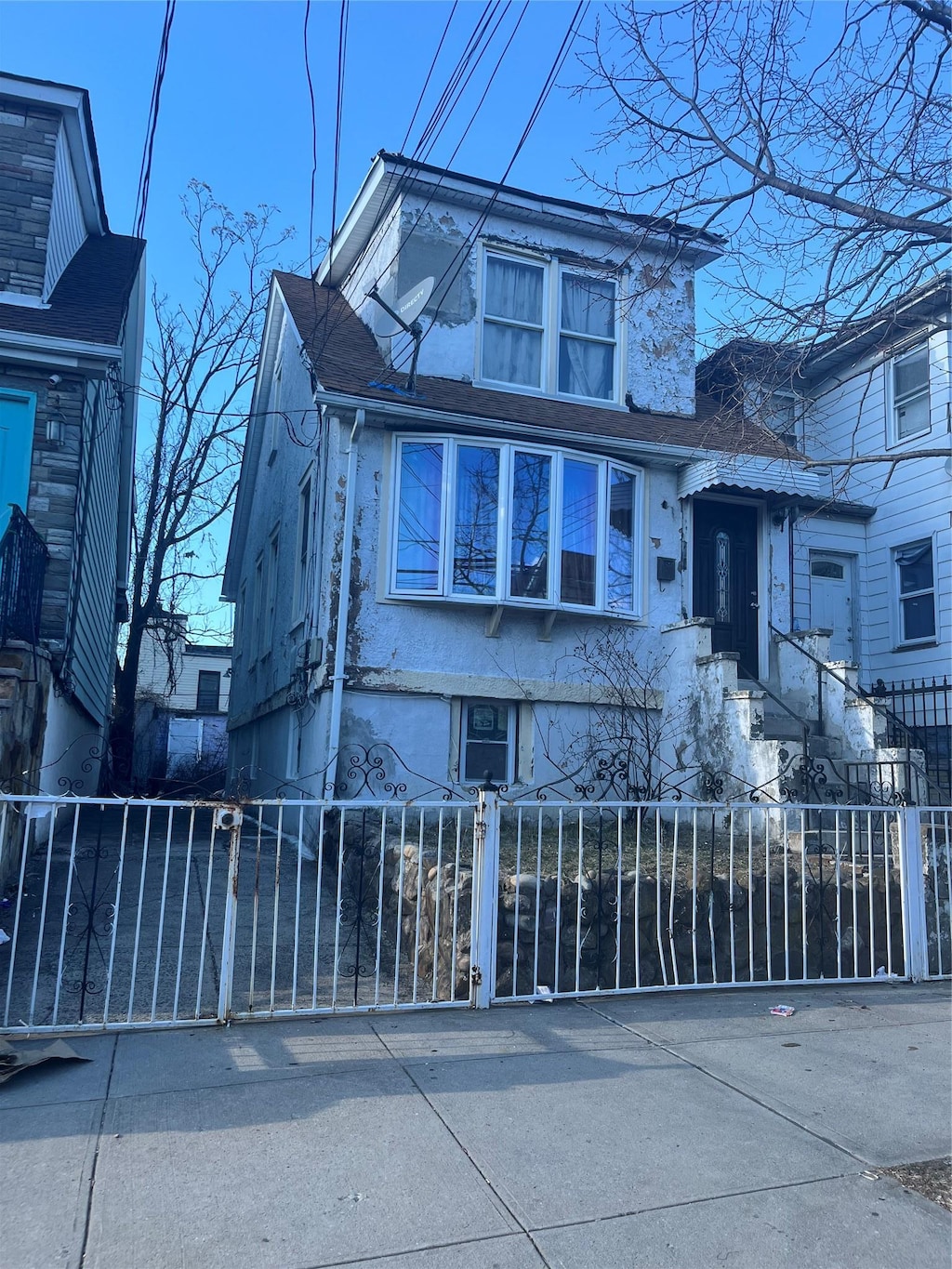 1467 Hicks St, Bronx, NY 10469 - view of front facade with a fenced front yard and stucco siding