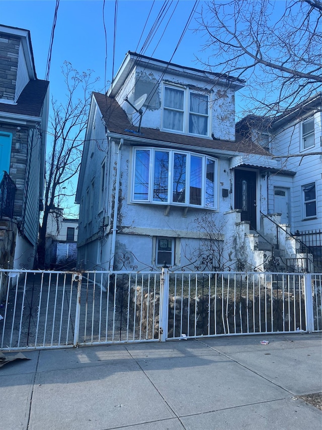 1467 Hicks St, Bronx, NY 10469 - view of front facade with a fenced front yard and stucco siding