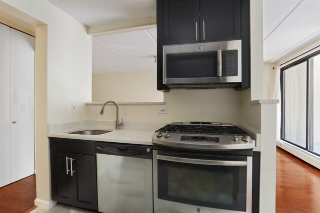 1155 Warburton Ave Unit 4G, Yonkers, NY 10701 - kitchen with appliances with stainless steel finishes, dark cabinets, light wood finished floors, and healthy amount of natural light