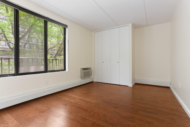 1155 Warburton Ave Unit 4G, Yonkers, NY 10701 - unfurnished bedroom featuring baseboard heating, a wall mounted air conditioner, wood finished floors, and a closet