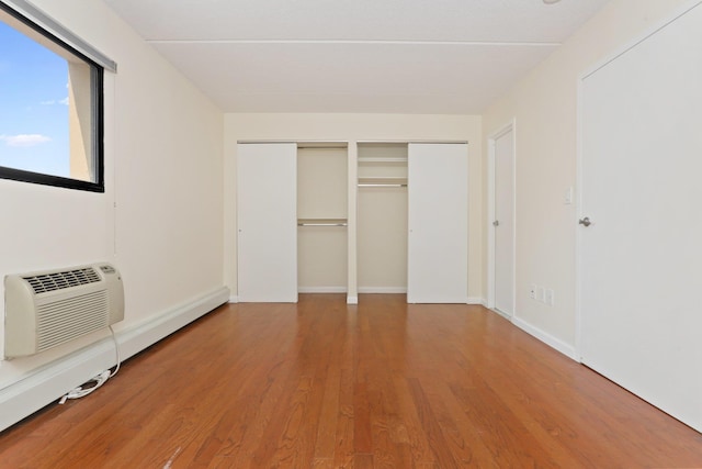 1155 Warburton Ave Unit 4G, Yonkers, NY 10701 - unfurnished bedroom featuring wood finished floors, an AC wall unit, and two closets