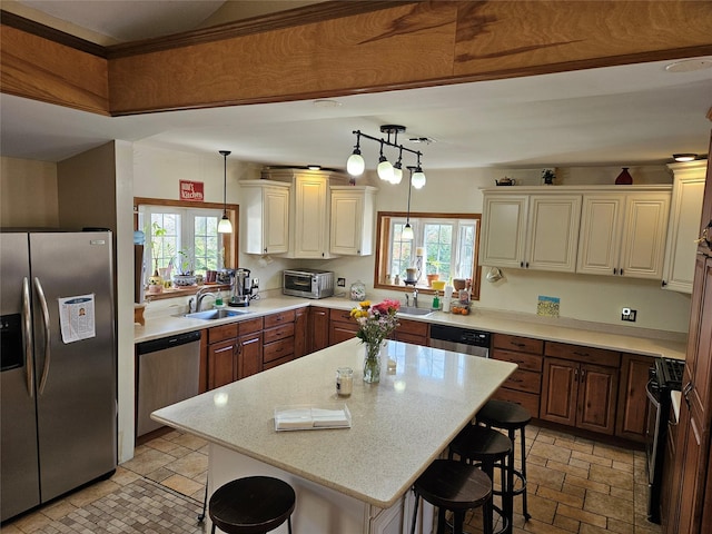 526 Hazel Dr, Woodmere, NY 11598 - kitchen with stainless steel appliances, a sink, a breakfast bar, and a center island