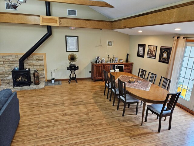 526 Hazel Dr, Woodmere, NY 11598 - dining area featuring vaulted ceiling, a wood stove, healthy amount of natural light, light wood finished floors, and recessed lighting