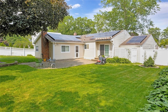 53 Wiltshire Dr, Commack, NY 11725 - back of house featuring a chimney, roof mounted solar panels, and a patio area