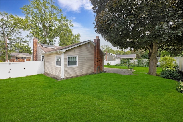 53 Wiltshire Dr, Commack, NY 11725 - rear view of property with a chimney, solar panels, and a fenced backyard