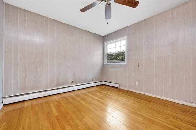 53 Wiltshire Dr, Commack, NY 11725 - empty room featuring a baseboard heating unit, hardwood / wood-style flooring, and a ceiling fan