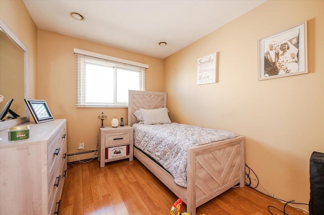 22 Cheshire Rd, Inwood, NY 11096 - bedroom featuring a baseboard heating unit and light wood-style floors