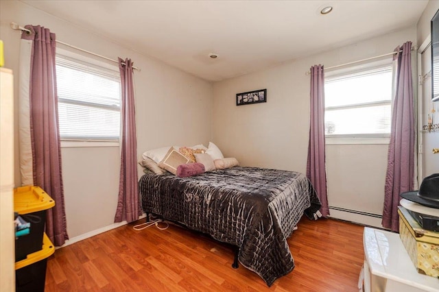 22 Cheshire Rd, Inwood, NY 11096 - bedroom featuring wood finished floors, a baseboard radiator, and recessed lighting
