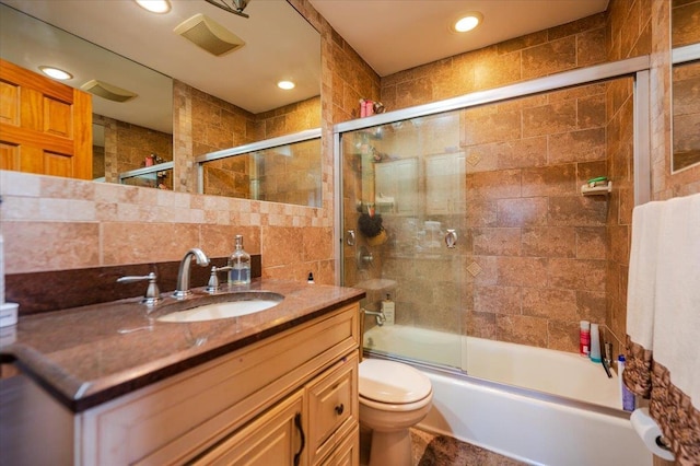 22 Cheshire Rd, Inwood, NY 11096 - bathroom featuring tile walls, toilet, vanity, bath / shower combo with glass door, and recessed lighting