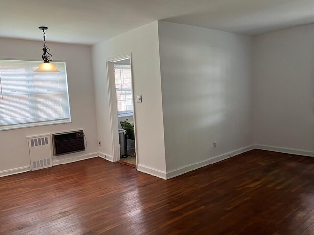 210-12 69th Ave Lower, Lower, Oakland Gardens, NY 11364 - unfurnished living room with radiator, dark wood-style flooring, baseboards, and heating unit