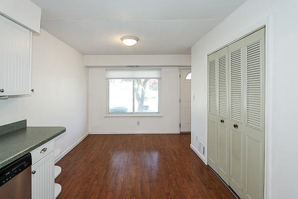 223 Springmeadow Dr Unit E, Holbrook, NY 11741 - unfurnished dining area featuring dark wood-style flooring and baseboards