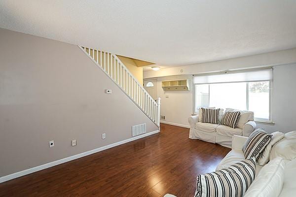 223 Springmeadow Dr Unit E, Holbrook, NY 11741 - living room with stairway, wood finished floors, and baseboards