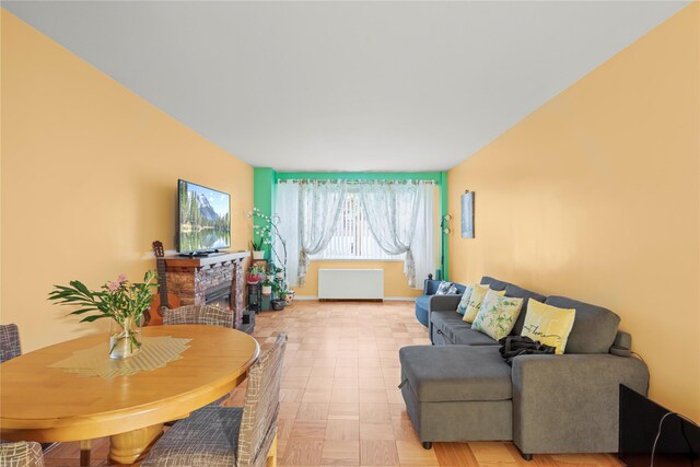230 Garth Rd Unit 1A1, Scarsdale, NY 10583 - living room featuring a glass covered fireplace, radiator, and light floors