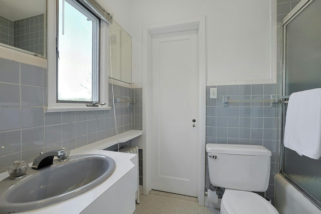 286 Lyncroft Rd, New Rochelle, NY 10804 - bathroom with tile walls, combined bath / shower with glass door, vanity, and tile patterned flooring