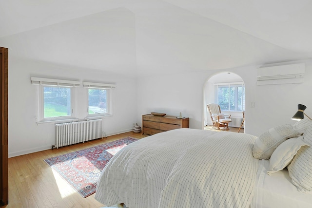 286 Lyncroft Rd, New Rochelle, NY 10804 - bedroom with radiator heating unit, a wall unit AC, multiple windows, arched walkways, and high vaulted ceiling