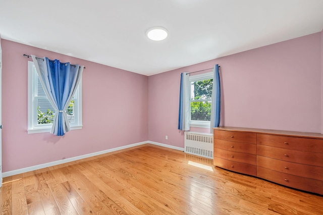 859 Franklin Ave, Valley Stream, NY 11580 - unfurnished room featuring radiator heating unit and light wood-style floors