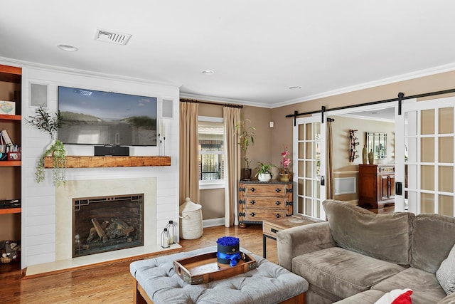 15707 22nd Ave, Whitestone, NY 11357 - living area featuring ornamental molding, wood finished floors, a barn door, a large fireplace, and recessed lighting