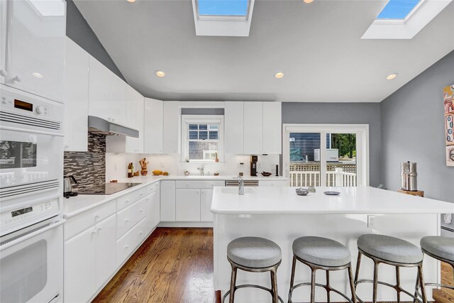 62 Woodhail St, Lido Beach, NY 11561 - kitchen with a skylight, black electric stovetop, a kitchen breakfast bar, recessed lighting, and an island with sink