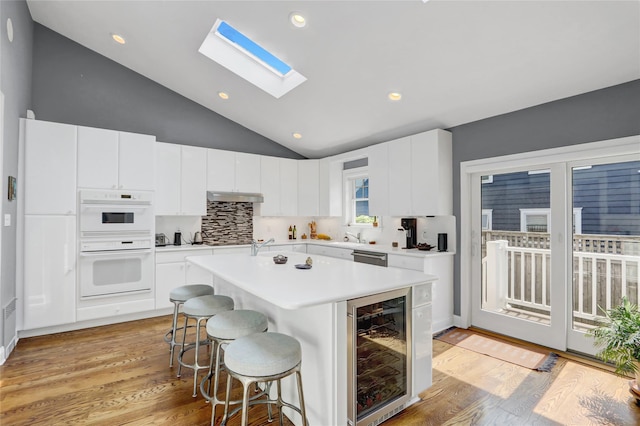 62 Woodhail St, Lido Beach, NY 11561 - kitchen featuring wine cooler, vaulted ceiling, a kitchen breakfast bar, tasteful backsplash, and double oven