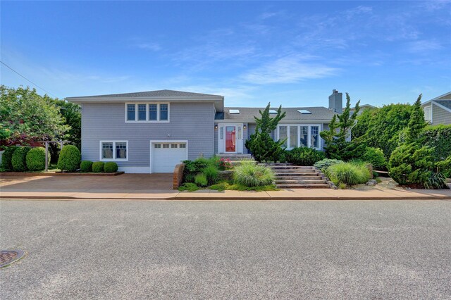 62 Woodhail St, Lido Beach, NY 11561 - tri-level home featuring a garage, concrete driveway, a chimney, and stairs