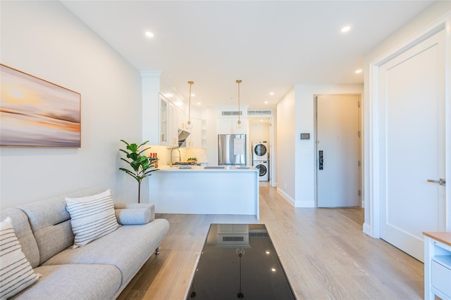 4209 Hampton St Unit 2A, Elmhurst, NY 11373 - living room featuring stacked washing machine and dryer, light wood-style flooring, recessed lighting, and baseboards