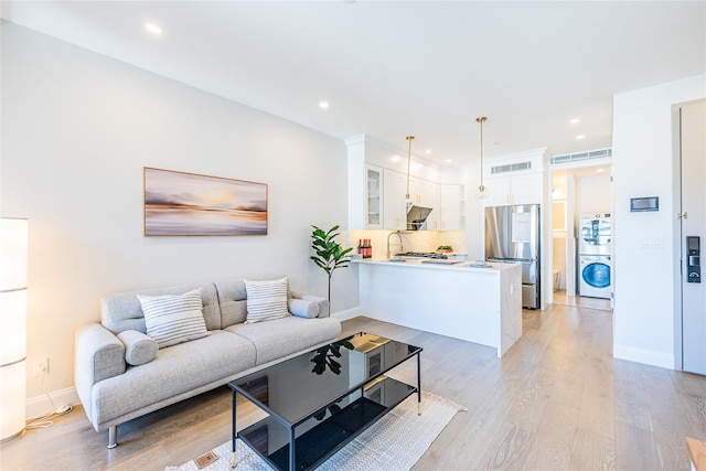 4209 Hampton St Unit 2A, Elmhurst, NY 11373 - living area with light wood finished floors, baseboards, recessed lighting, and stacked washer / drying machine