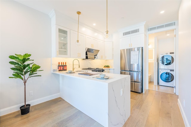 4209 Hampton St Unit 2A, Elmhurst, NY 11373 - kitchen with freestanding refrigerator, stacked washing machine and dryer, a peninsula, glass insert cabinets, and light wood-style floors