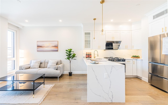 4209 Hampton St Unit 2A, Elmhurst, NY 11373 - kitchen with freestanding refrigerator, glass insert cabinets, light wood-type flooring, white cabinetry, and decorative light fixtures