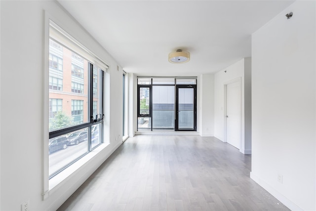 4104 27th St Unit 8C, Long Island City, NY 11101 - unfurnished room with wood finished floors, baseboards, and fire sprinkler in ceiling