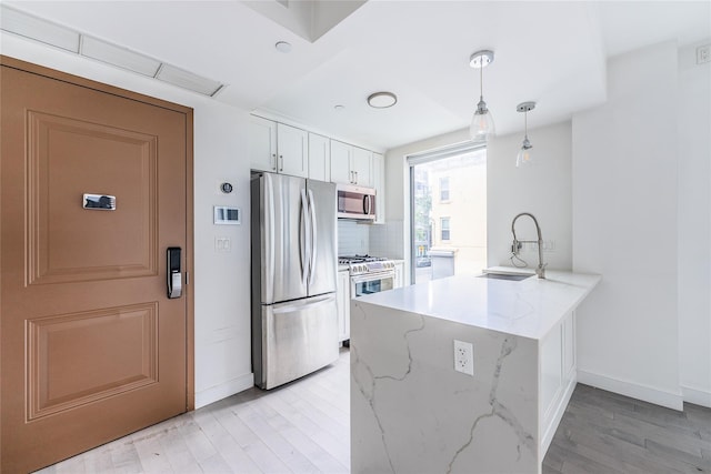 4104 27th St Unit 8C, Long Island City, NY 11101 - kitchen with stainless steel appliances, a sink, a peninsula, white cabinetry, and baseboards