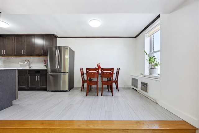 134-54 Maple Ave Unit 3W, Flushing, NY 11355 - kitchen featuring freestanding refrigerator, light countertops, dark brown cabinetry, crown molding, and baseboards