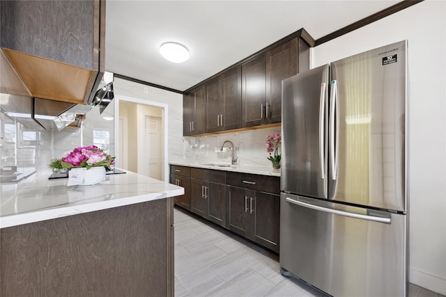 134-54 Maple Ave Unit 3W, Flushing, NY 11355 - kitchen with freestanding refrigerator, a sink, dark brown cabinetry, tasteful backsplash, and light stone counters